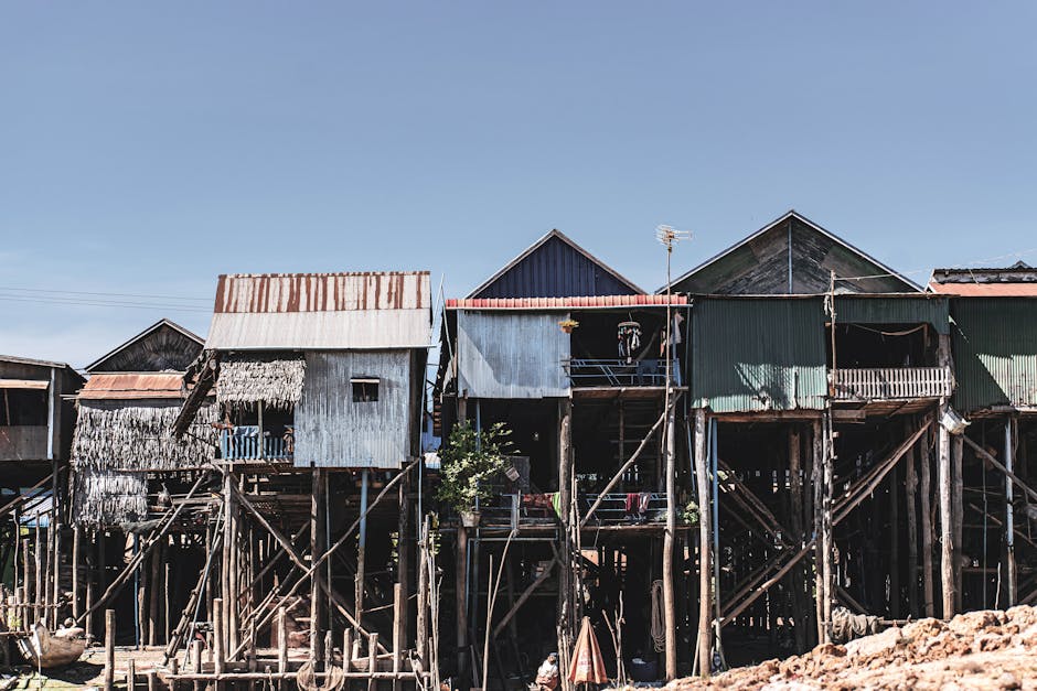 Stilt houses in Kampong Phluk, Siem Reap, showcasing traditional architecture against a clear sky.