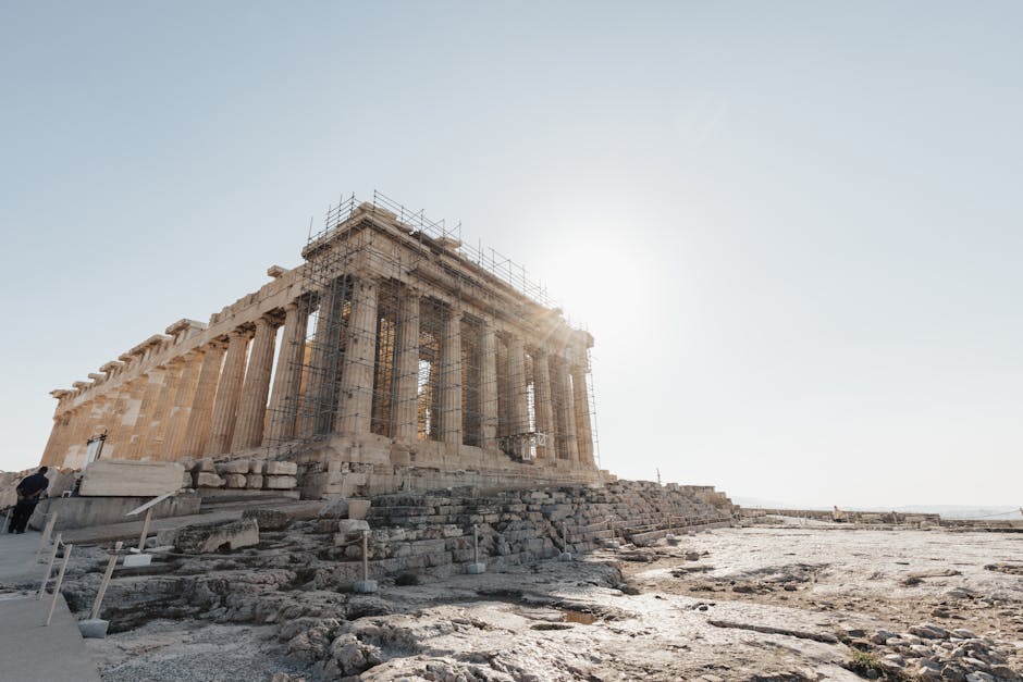 View of the Parthenon in Athens, Greece, with scaffolding during restoration in bright daylight.