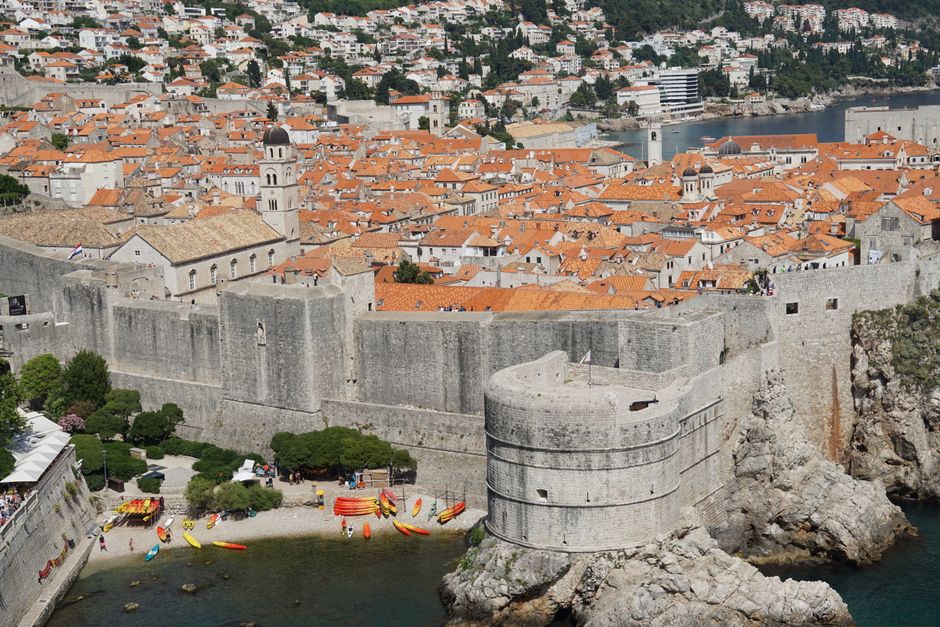 Explore the historic city walls of Dubrovnik, Croatia with stunning aerial views and vibrant rooftops.