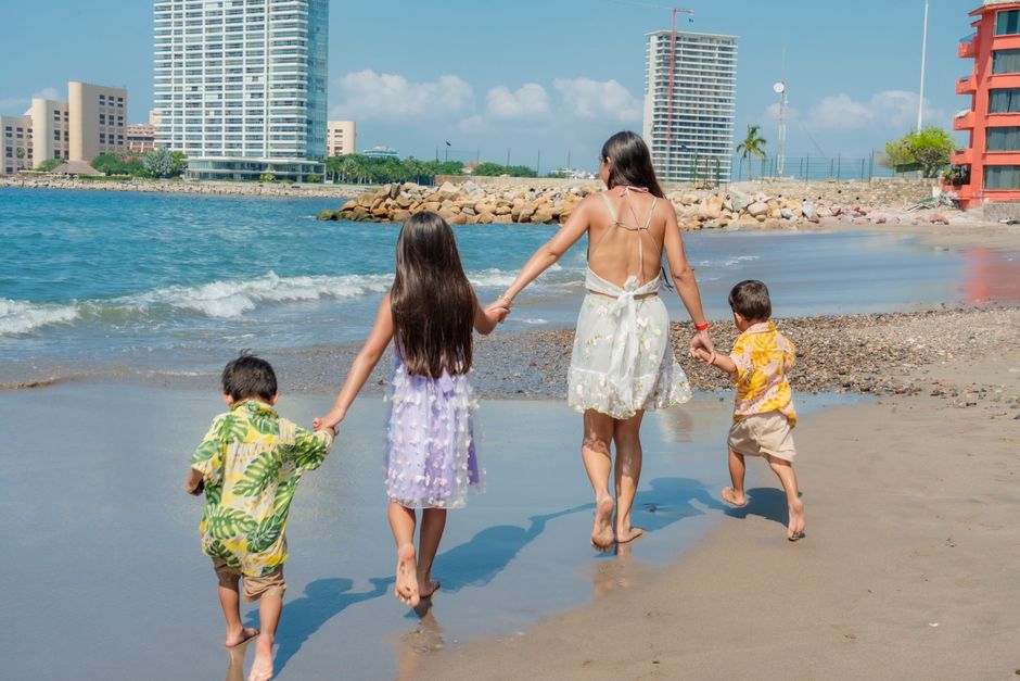 Family with young children walking along the beach on a spring holiday