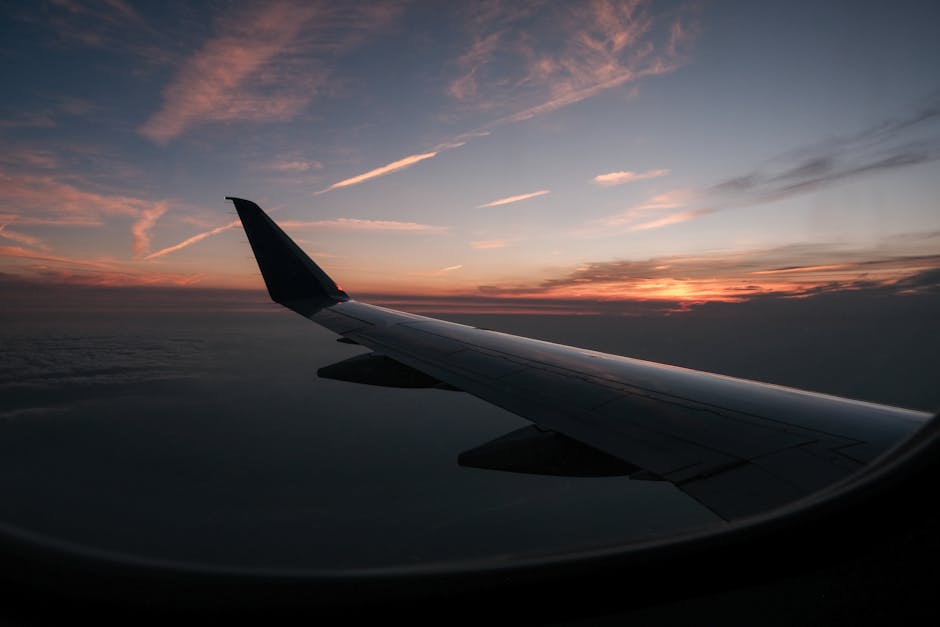 A serene view of an airplane wing against a vibrant sunset sky from the cabin.