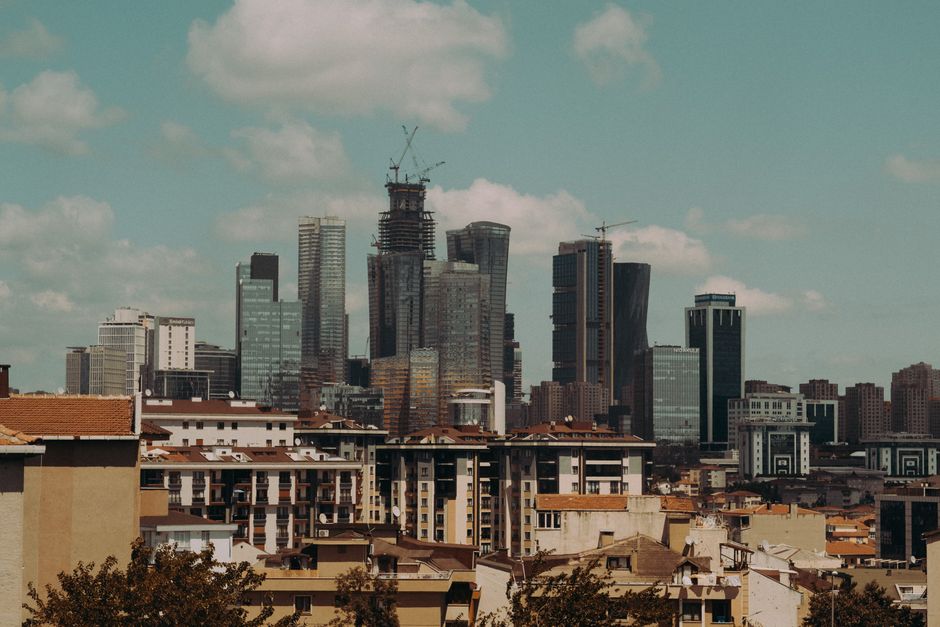 A vibrant city skyline with modern skyscrapers under a blue sky, showcasing urban development.