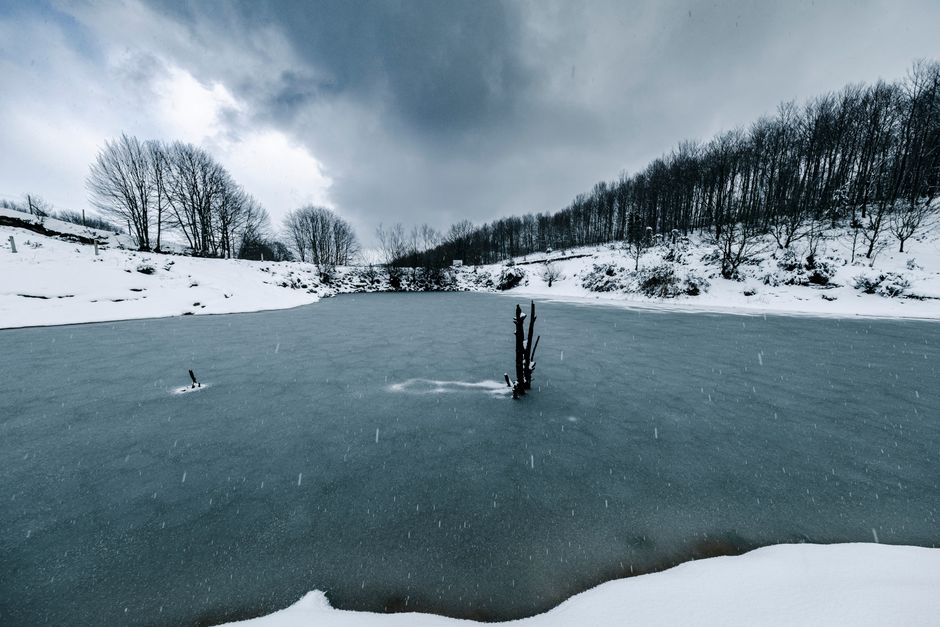 Partly frozen lake with snowy banks on a cold winter walk