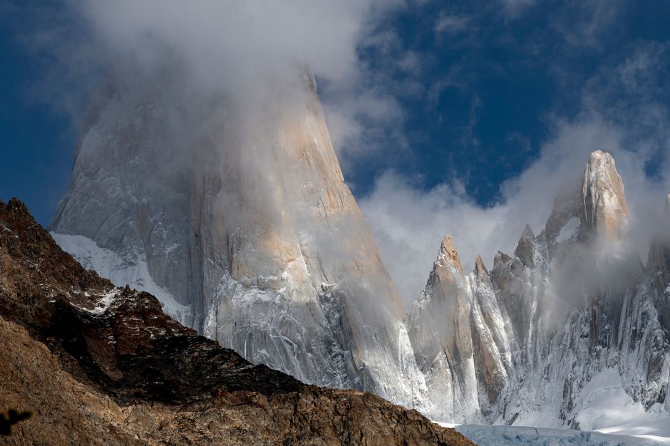 Stunning view of Patagonia's Cerro Torre with clouds enveloping the rugged mountain peaks.