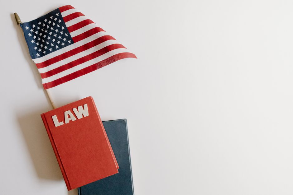 Flat lay of an American flag and a law book symbolizing justice and patriotism.