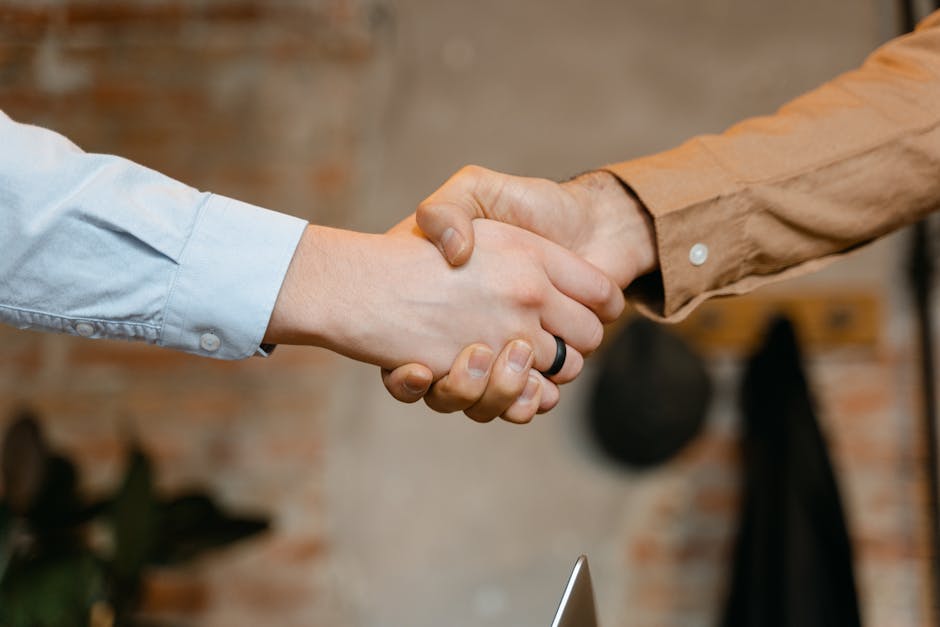 Close-up of a firm handshake symbolizing a business deal agreement.