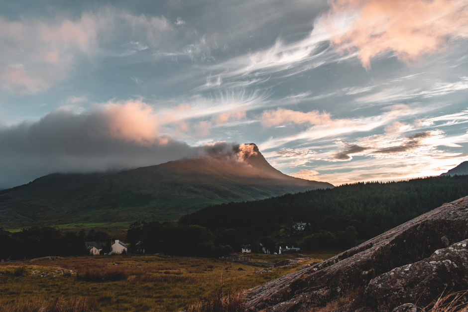 Picturesque view of a rural Welsh mountain, forest, and cloudscape at sunset.