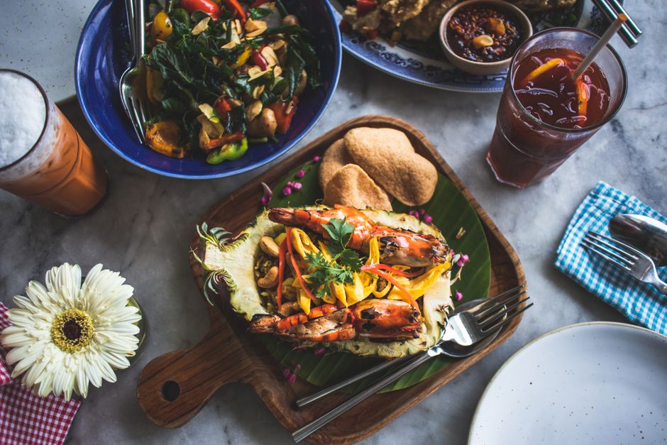 A vibrant assortment of Thai dishes including shrimp on a wooden platter, perfect for food lovers.
