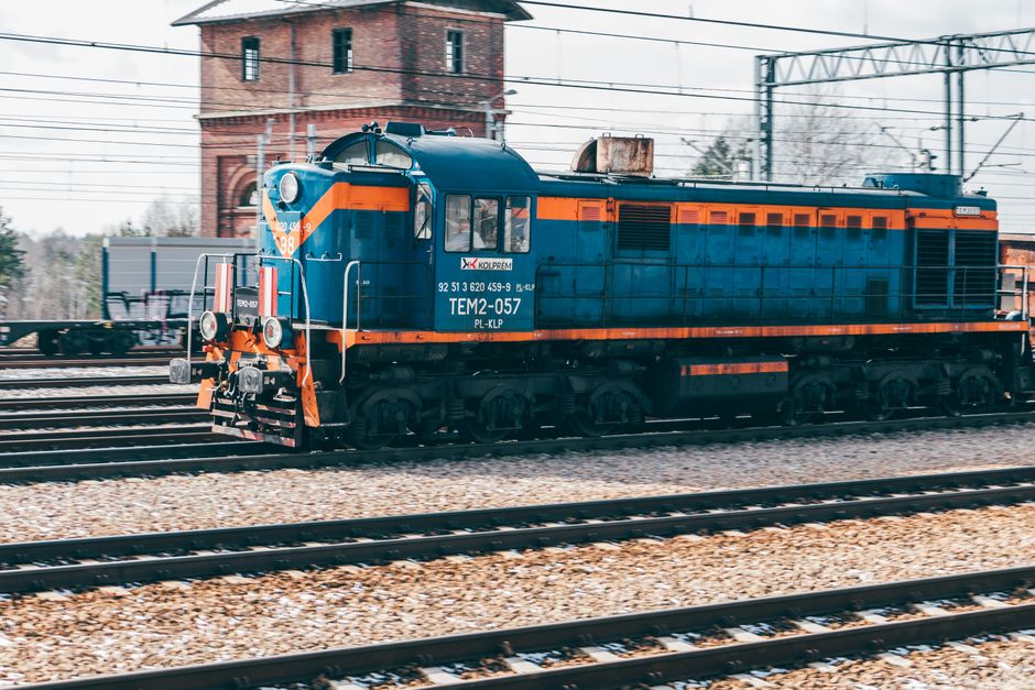 Vivid blue locomotive on tracks in Trzebinia, Poland, with a vintage industrial background.