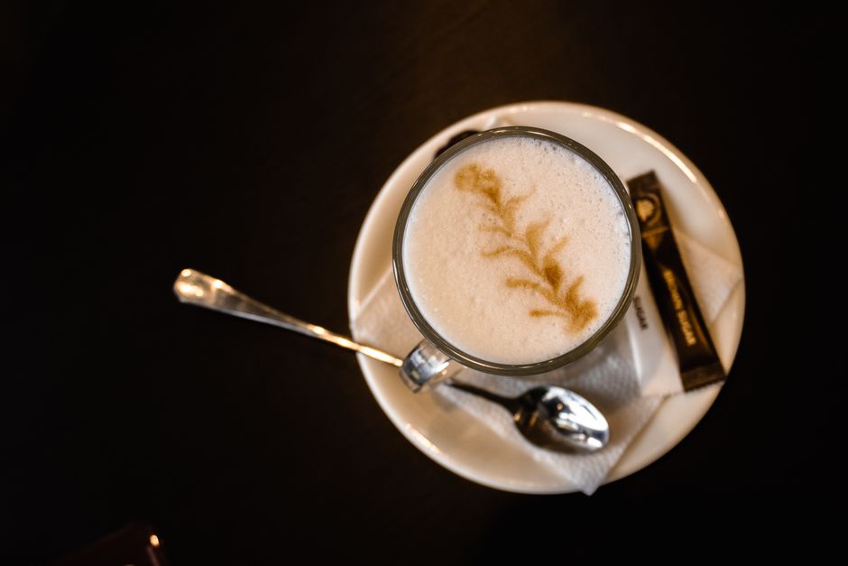 Aerial perspective of a cappuccino with latte art on a saucer. Perfect for coffee lovers.